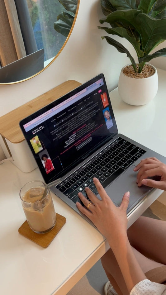 Woman Scrolling Through Laptop on Table with Coffee